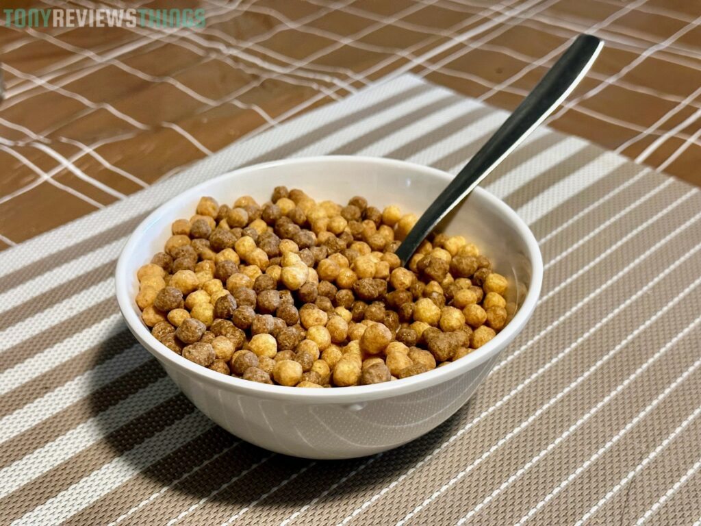 A bowl of Reese's Puffs Minis on a decorative tablecloth.
