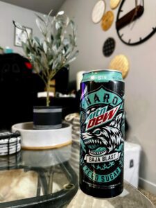 An image of a can of Hard Mountain Dew Baja Blast on a coffee table.