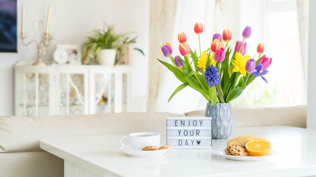 Banner image for the post, Mastering Your Morning Routine: A Guide to Productivity and Success, featuring flowers, coffee, and a sign that reads "Enjoy your day <3"